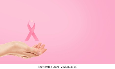 Pink Breast Cancer Awareness Ribbon. Female hand holding pink ribbon flying symbol of fight against breast cancer. Breast cancer awareness and October Pink day, world cancer day. Top view. Mock up. - Powered by Shutterstock