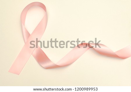 Pink breast cancer awareness ribbon on pink background; women's healthcare concept; women's medical care concept