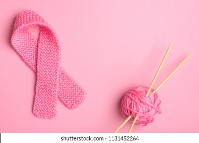 Pink Breast Cancer Awareness Symbol knitted in pink yarn with ball of yarn and needles on sides with center room or space for copy, text or your words.  Horizontal with a trendy flat layout design - Powered by Shutterstock