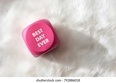 Pink button with white lettering that says Best Day Ever on white fur background