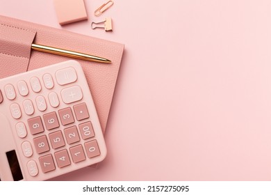 pink calculator and accessories on pink table, minimal workspace style, business concept High quality photo