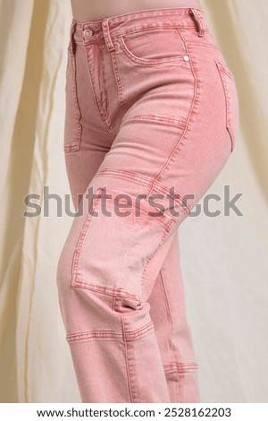 Pink cargo pants featuring multiple pockets along the legs, a relaxed fit, and an adjustable waistband. The vibrant color adds a modern twist to the utilitarian style