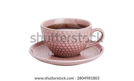 Pink ceramic tea cup with embossed heart pattern on matching saucer