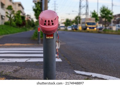 Pink Children's Helmet Hung On A Road Bollard