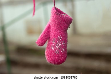 pink children's mitten hangs on a tree. Missing child. Lost child missing concept.