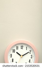 Pink clock on grey background. Top view. Macro