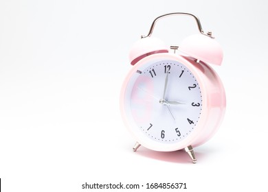 
Pink Clock On White Background.