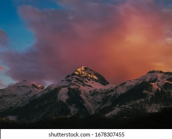 Pink Clouds Over A Snow-capped Mountaintop