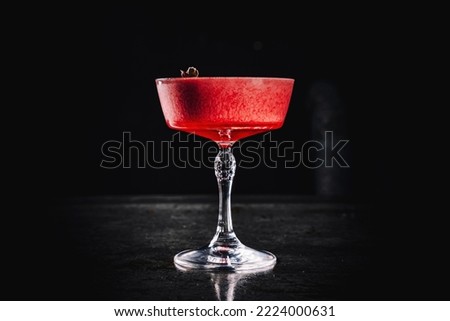 Pink cocktail in glass on the black background