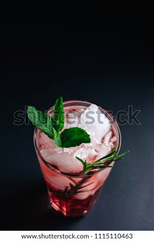 pink cocktail with mint and rosemary on black background close-up  view from above