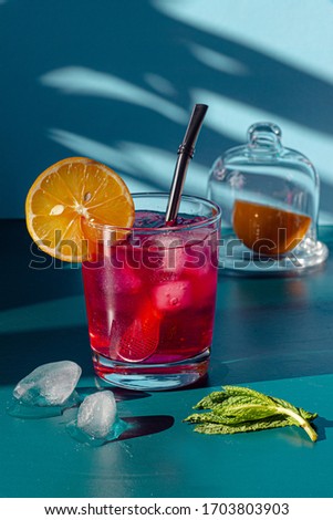 pink cocktail on a blue background with lemon