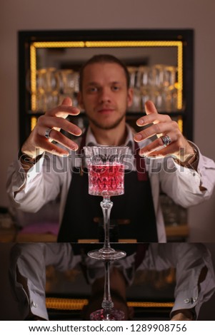 Pink cocktail in retro glass on black mirror table top
