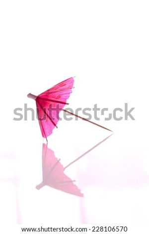 Pink coctail umbrella isolated on white 