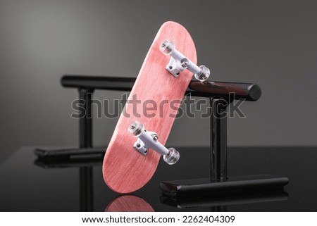 Pink color fingerboard with white chassis on black metal railings on a gradient background