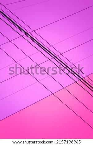 Pink color sky background in two gradient with black lines of power cables crisscrossing