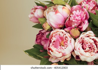 Pink colored bunch of Peony flowers.
Beige background.