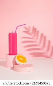 Pink Colored Can With Cut In Half Orange Fruit On Product Podium And Shadow. Summer Drink Minimal Concept. Pink Aesthetic.