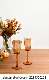 Pink Colored Crystal Champagne Glass, Autumn Flowers On Table