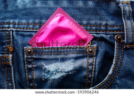 Pink condom in the pocket of a blue jeans