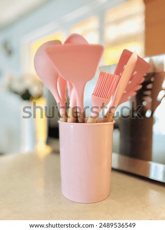 Pink Cookware placed on a table next to the microwave with a homelike background

