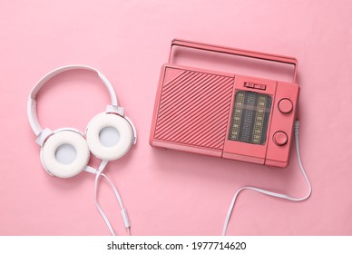 Pink Cool Radio Receiver And Headphones On Pink Background. Minimal Musical Concept. Top View. Flat Lay