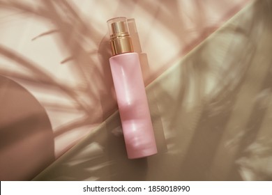 Pink Cosmetic Beauty Bottle From Above On Pastel Background. Brand Ad Mockup. Lights And Shadows From Palm Leaves. Copy Space, Minimalism Beauty Blogging Flatlay Concept