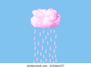 Pink cotton cloud with rain drops on blue sky background. Cloudy weather or dreaming concept in surreal fairy style. High quality photo