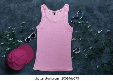 Pink cotton tank top mockup on dark background. Blank plain t-shirt template for creative design. Female summer sunglasses clothing fashion sleeveless undershirt. Casual clothes baseball cap snapback.