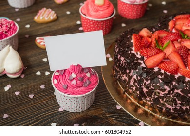 Pink Cupcakes On Wooden Table With Blank Business Card.