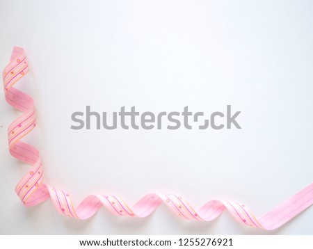 Pink curly ribbon on a  white background