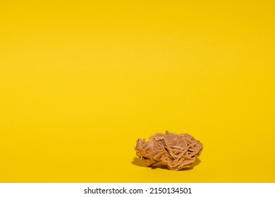 Pink Desert Rose Stone On A Yellow Construction Paper Background. 