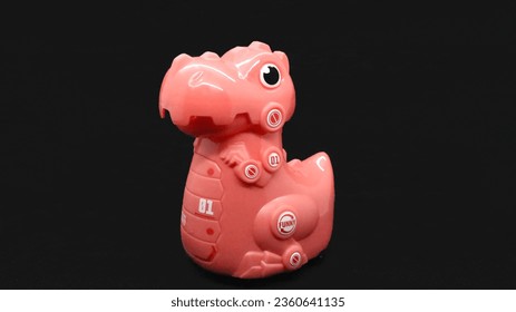 Pink dinosaur toy isolated on black background - Powered by Shutterstock