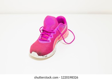 Pink Dirty Sneaker. One Bright Pink Muddy Sport Shoe On White Background - Close Up. Modern Sport Lifestyle Concept.