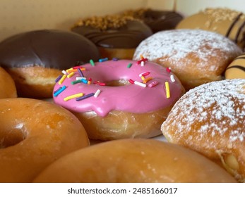 A pink doughnut among other doughnuts