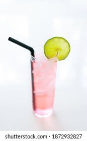 Pink Drink With Lime Garnish On White Background