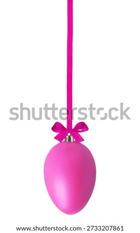 Pink Easter egg hanging on ribbon against white background