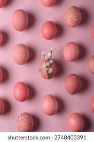 Pink Easter eggs pattern on pastel backdrop with central egg wrapped in twine and pussy willow, minimal spring holiday flat lay