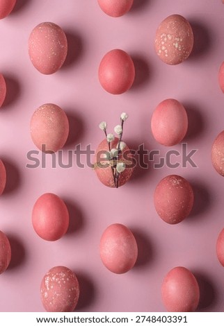 Pink Easter eggs pattern on pastel backdrop with central egg wrapped in twine and pussy willow, minimal spring holiday flat lay