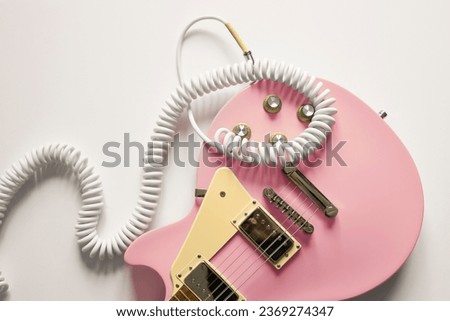 Pink electric guitar on white background. Music wallpaper