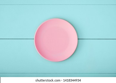 Pink Empty Plate On Turquoise Wooden Table. Top Down View With Copy Space. 