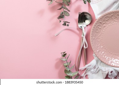 Pink Empty Plate, White Napkin, Cutlery Set With Bow And Decorative Eucalyptus Twigs On Pink Pastel Background. Festive Table Setting For Valentine’s Day Or Easter Concept.