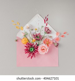 Pink Envelope Full Of Various Flowers. Flat Lay. Love Concept.