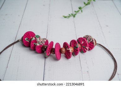 Pink Fabric Necklace With Coconut Shell  Beads On White Wooden Table. Etnic Handmade Jewelery.