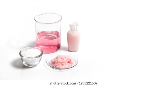 Pink flake chemicals, Potassium Permanganate Liquid and Cetyl esters wax on white laboratory table.