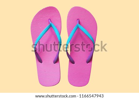 Pink flip flops isolated on yellow background. Top view