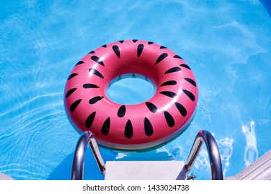 Pink Floatie Inflatable Doughnut In A Pool, Blue Water, Chill, Tanning Under Sun.                           