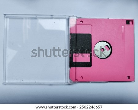 Pink floppy disk magnetic computer data storage support isolated on white background. Retro style floppy diskette back view. With the casing.