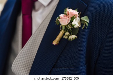 Pink Flower Detail On The Lapel Of The Groom's Blue Suit