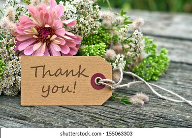 pink flowers and card with lettering thank you/thank you/english