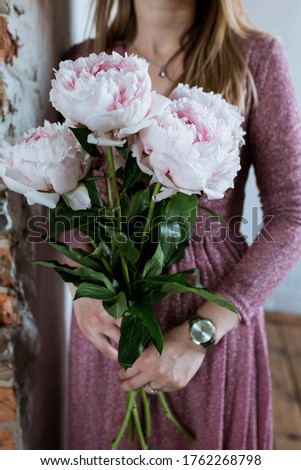 Similar – Woman arranges flower bouquet with roses in vase